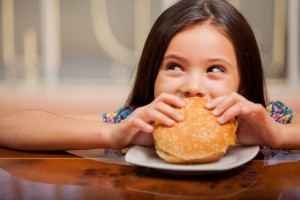 Little girl eating a hamburger